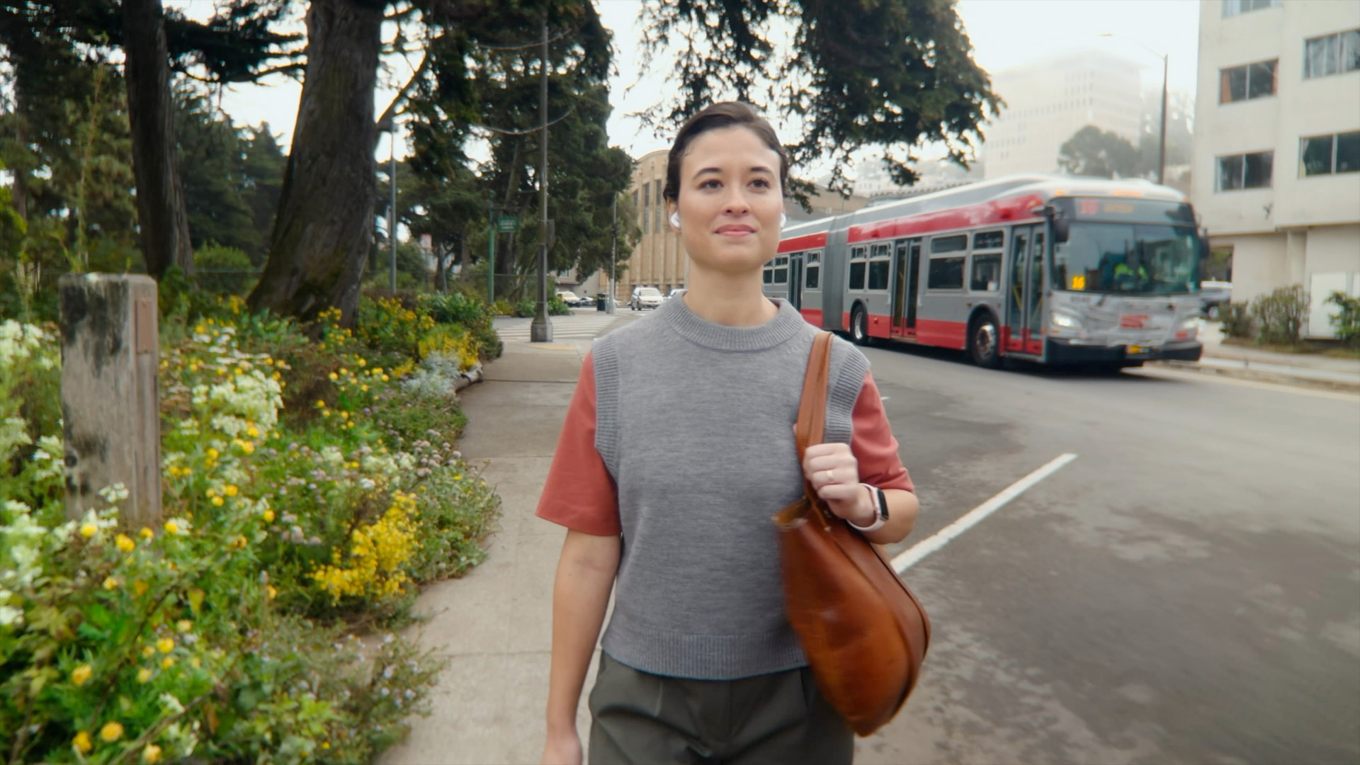 Person wearing Apple AirPods 4 with Active Noise Cancellation near city traffic — official Apple image