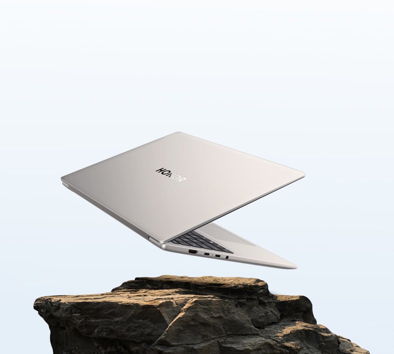 HONOR MagicBook 16 2026 open laptop floating above a rocky landscape