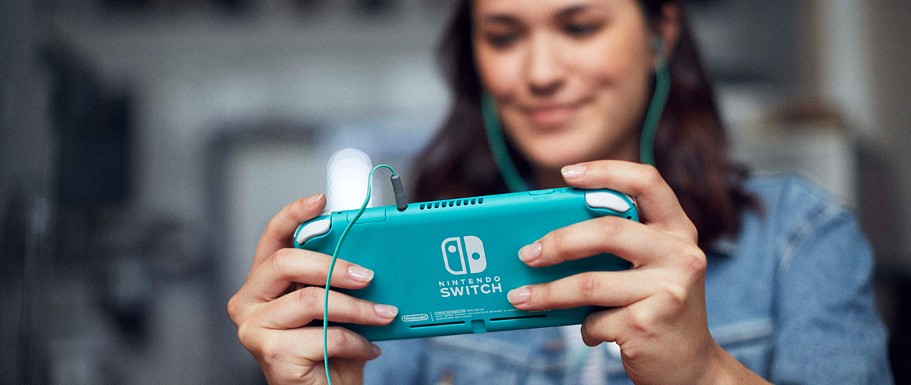 Nintendo Switch Lite Turquoise being played outdoors with rear casing visible