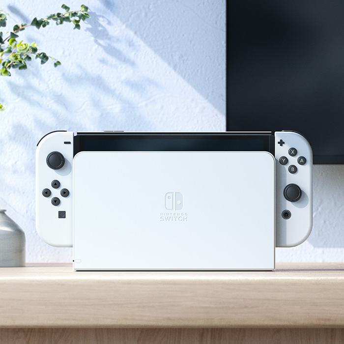 Nintendo Switch OLED White console seated in the matching white dock