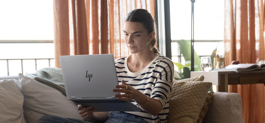 HP OmniBook X Flip 16-as0773ng Glacier Silver, using the laptop on a sofa